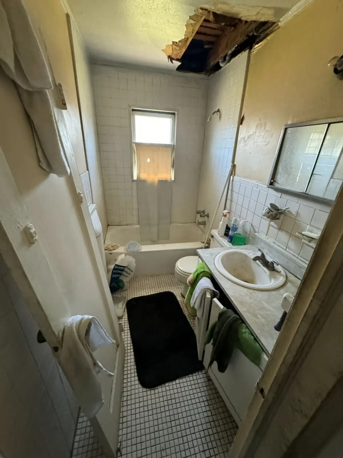 Selling a house with mold in Valley Stream: bathroom with a hole open in the ceiling above the tub