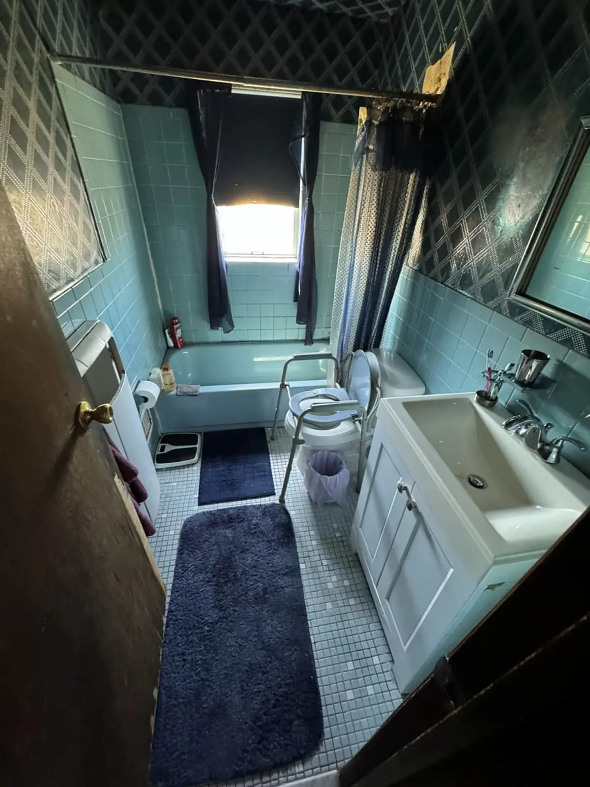 Downsizing or retiring in Valley Stream: dated bathroom with blue tile and a pedestal sink