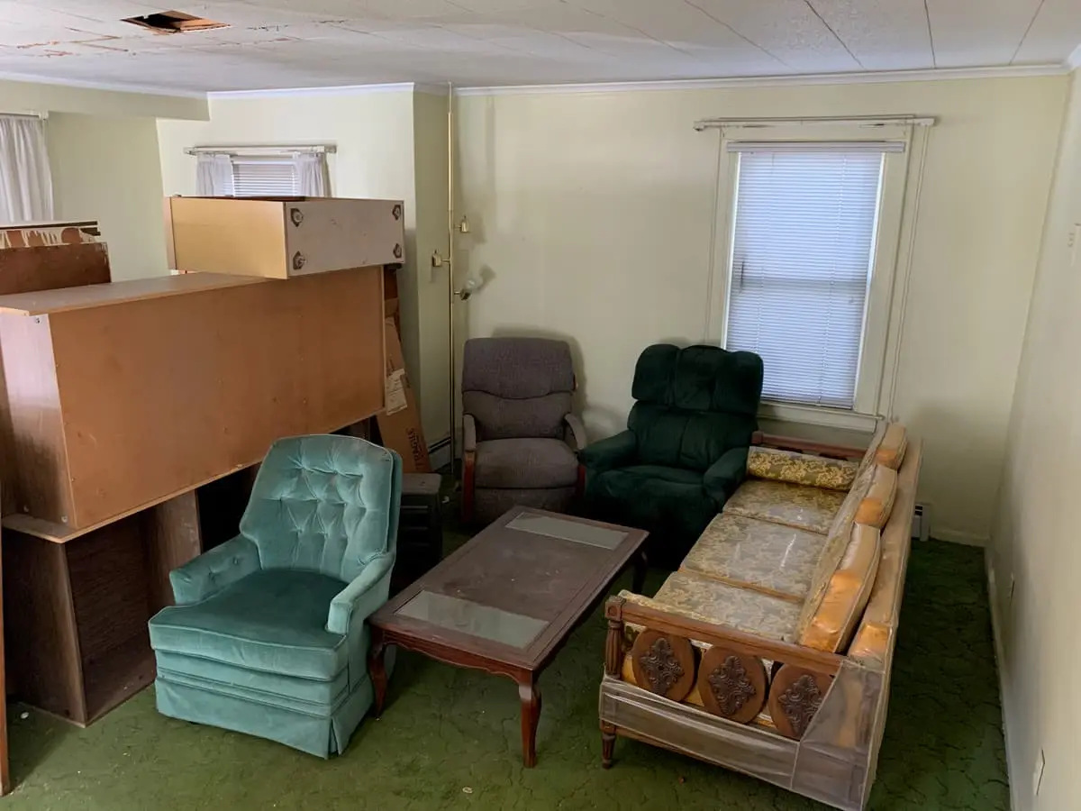 Selling a house with multiple heirs in Valley Stream: living room with vintage armchairs and green carpet