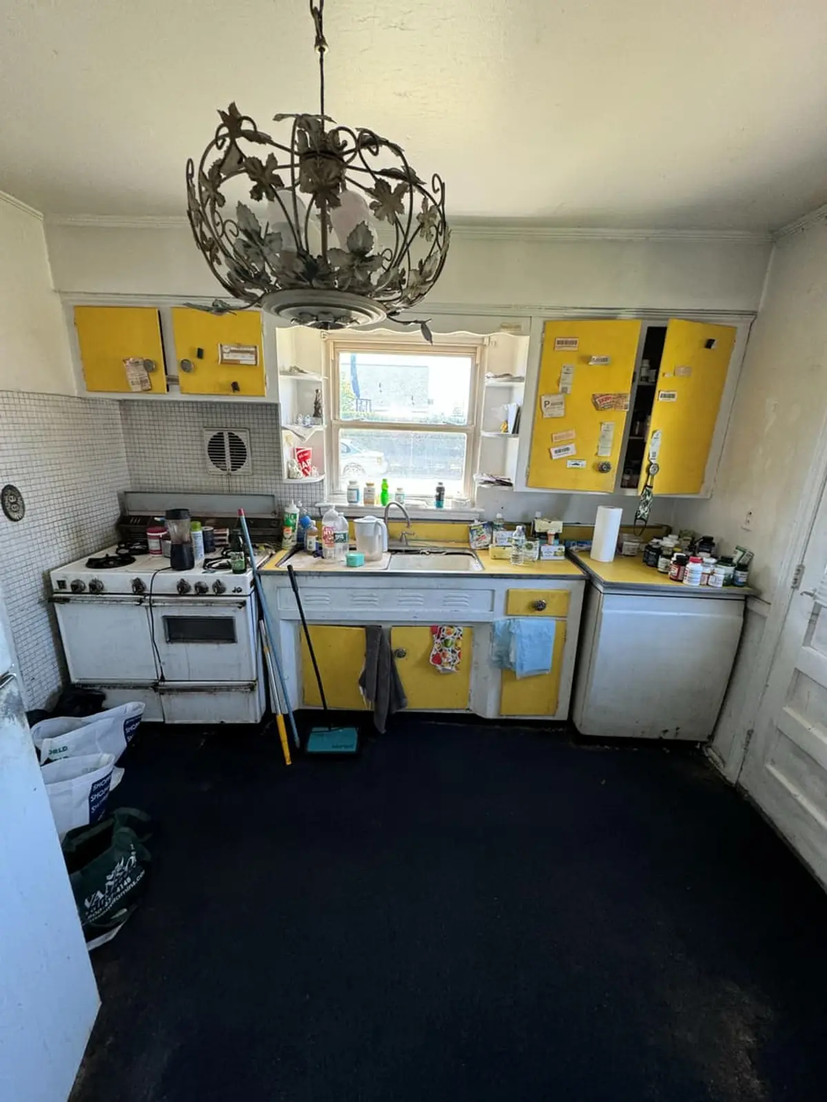 Selling a house with a failed cesspool in Valley Stream: second-floor kitchen with yellow cabinets and an old range